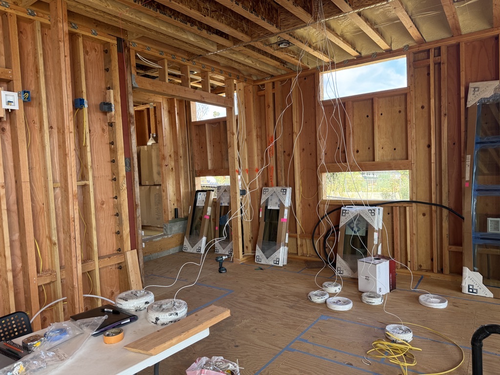 Cable runs in progress through exposed framing before the walls are closed.