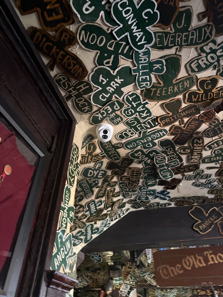 Turret camera fitted near a doorway in a decorated pub interior.